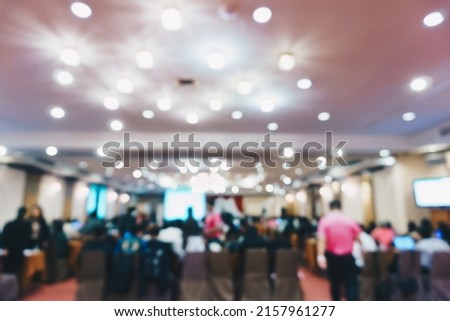 Blurred background group of people in seminar conference hotel room with monitor