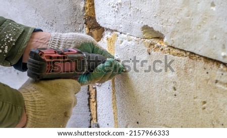 Repair, building and home concept. Electric screwdriver in hand. Close-up of male with electric screwdriver for construction.