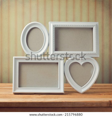 Picture frame on wooden table over vintage background