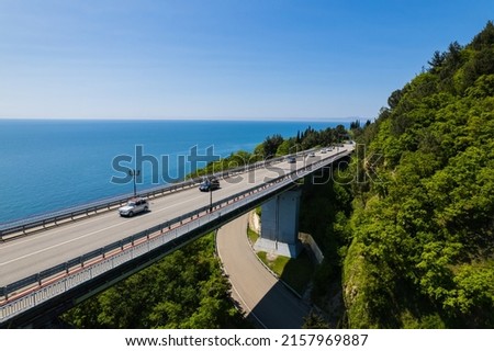 The Zubova Schel Viaduct is a road bridge, Dzhubga - Adler federal road. Aerial view of car driving along the winding mountain road in Sochi, Russia. Royalty-Free Stock Photo #2157969887