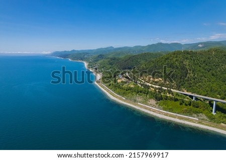 The Zubova Schel Viaduct is a road bridge, Dzhubga - Adler federal road. Aerial view of car driving along the winding mountain road in Sochi, Russia. Royalty-Free Stock Photo #2157969917