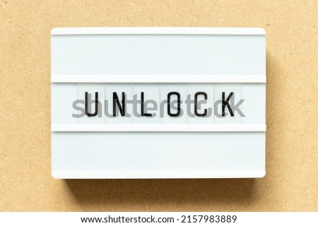 Lightbox with word unlock on wood background