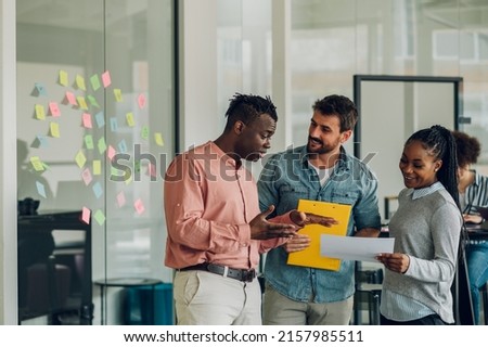 Three diverse business team discussing and planning projects using analytical papers during a meeting in the office. Business and finance concept. Multiracial business colleagues checking documents. Royalty-Free Stock Photo #2157985511