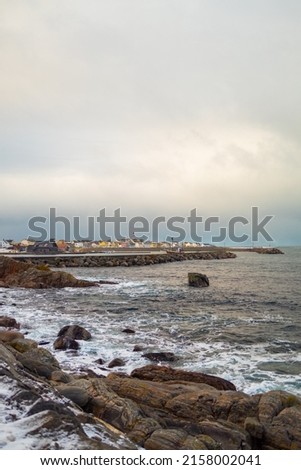 The beautiful vertical shot of a seashore stones and a blue ocean foam waves