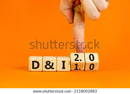 Diversity and inclusion 2.0 symbol. Businessman turns cubes and changes words Diversity and Inclusion 1.0 to 2.0. Beautiful orange background. Business Diversity and inclusion 2.0 concept. Copy space.