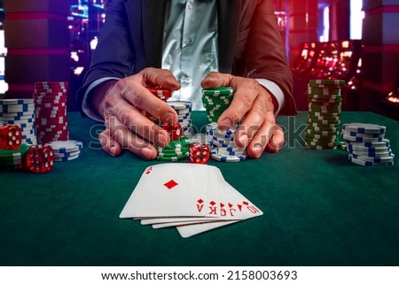 Gambling concept. Close up of Poker Player male hand Winning Royal Flush at casino, gambling club. Сasino chips or Casino tokens,  dice, poker cards, gambling man lucky guy, games of chance. Royalty-Free Stock Photo #2158003693