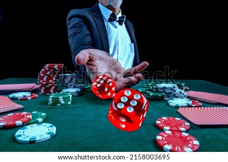 Gambling concept. Close up of Poker Player male hand throwing dice at casino, gambling club. Сasino chips or Casino tokens, poker cards, gambling man lucky guy spending time in games of chance. Royalty-Free Stock Photo #2158003695