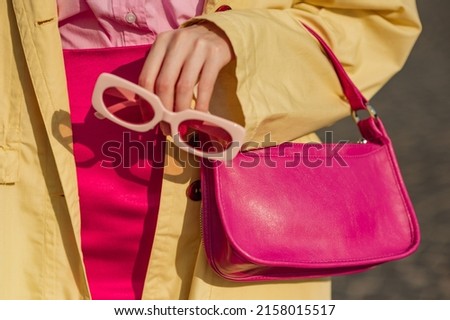 Close up trendy spring fashion outfit with pink, fuchsia color faux leather mini bag, sunglasses Royalty-Free Stock Photo #2158015517