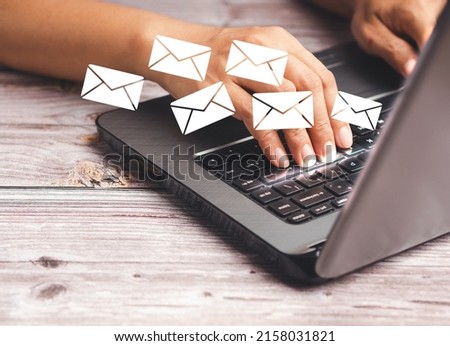 Businessman receives a new message with email icons on a virtual screen while sitting in the office. Email notification on the laptop. Email marketing concept. Close-up photo