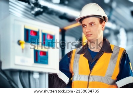Industrial engineer in helmet inspects or adjusts equipment at gas processing plant or plant. Authentic scene workflow.
