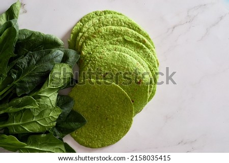 Green tortillas with spinach, round empty tortilla flatbreads for wraps, trendy mexican food, healthy snack concept