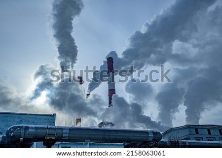 Smoking pipes of a thermal power plant in an industrial area of the city on a sunny frosty winter day Royalty-Free Stock Photo #2158063061