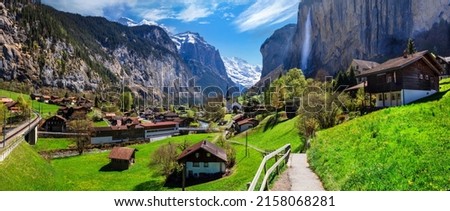 Switzerland nature and travel. Alpine scenery. Scenic traditional mountain village lauterbrunnen with waterfall  surrounded by snow peaks of Alps. Popular tourist destination and ski resort Royalty-Free Stock Photo #2158068281