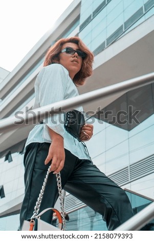 Non-binary executive young of LGBTQ community walking on stairs front of a building
