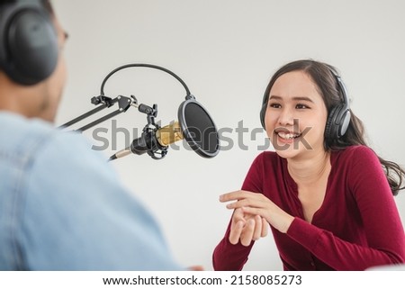 Smile two asian young woman, man radio hosts in headphones, microphone while talk, conversation, recording podcast in broadcasting at studio together. Technology of making record audio concept.