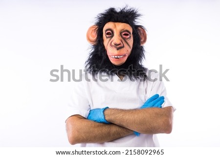 Person dressed in overalls with a mask, wearing a medical nurse outfit, with his arms crossed, on a white background. Monkeypox, pandemic, virus, epidemic, Nigeria and smallpox concept. Royalty-Free Stock Photo #2158092965