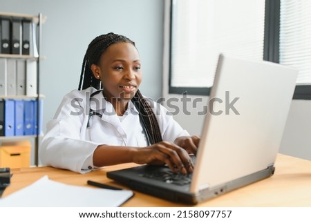 healthcare, medical and technology concept - african female doctor with laptop. Royalty-Free Stock Photo #2158097757