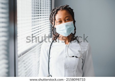 medicine, profession and healthcare concept - close up of african female doctor or scientist in protective facial mask.