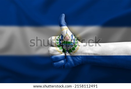 Hand making thumb up painted with flag of el salvador
