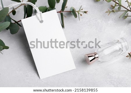 Rectangle white gift tag mockup with eucalyptus leaves on grey background, label tag mockup, Wedding favor tag for souvenir, sign for greeting message close up, element for design, close up
