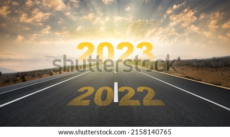 2023 anniversary. Transition from 2022 to the new year. Golden sunrise on asphalt empty road. New year concept with the number 2023 on the horizon. Royalty-Free Stock Photo #2158140765