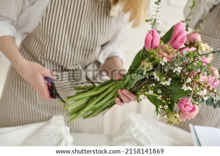 Young creative woman in a flower shop, using laptop. A startup of florist business. Royalty-Free Stock Photo #2158141869