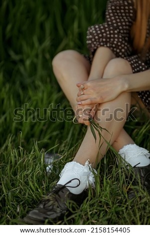legs of a girl sitting in the grass