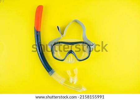 Black orange colored swimming goggles isolated on yellow background, summer idea, holiday preparation concept with protective goggles, swimming equipment, top view  Royalty-Free Stock Photo #2158155991