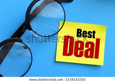 The words BEST DEAL on a small piece of yellow paper and blue background.