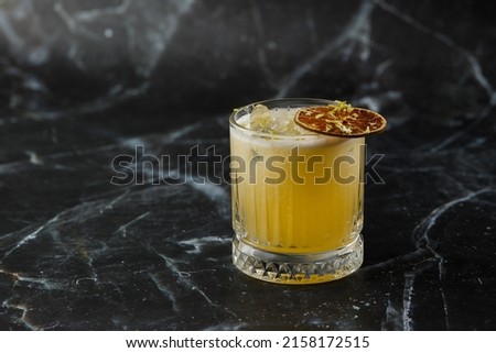 Fruit mixology with mezcal and dry lime on black marble background. Warm colored cocktails. Mezcal cocktail Royalty-Free Stock Photo #2158172515