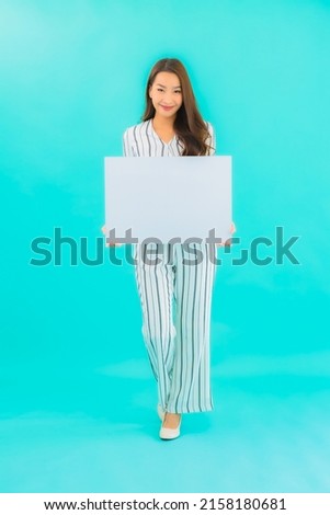Portrait beautiful young asian woman show white empty billboard on blue isolated background