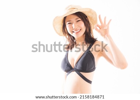 Asian swimsuit model wearing a black 2 piece bathing suit on a white background