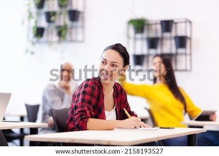 Multi ethnic students listening to a lecturer in a classroom. Smart young people rasing hands during class. Royalty-Free Stock Photo #2158193527