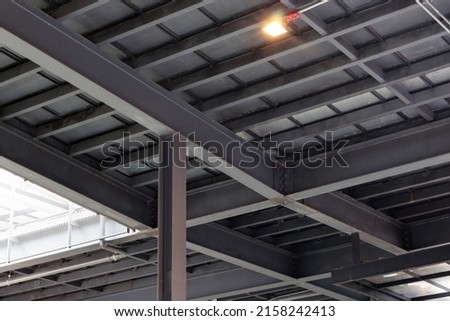 Picture of the roof structure and the building, installation of the base of columns and large steel beams made of strong materials. Royalty-Free Stock Photo #2158242413
