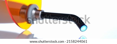 Dental apparatus curing light on white background with reflection closeup Royalty-Free Stock Photo #2158244061