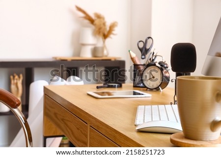 Closeup view of microphone, alarm clock and stationery on table