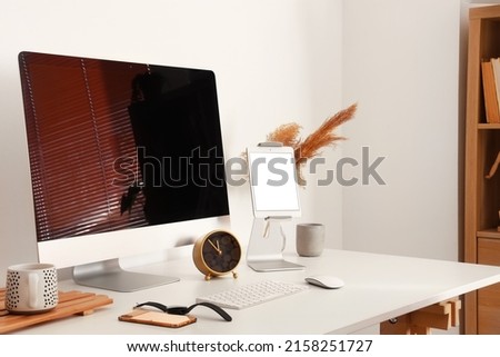 Workplace with modern gadgets near light wall Royalty-Free Stock Photo #2158251727