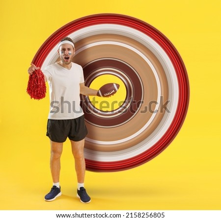 Male cheerleader with rugby ball on yellow background