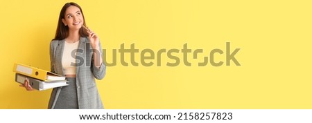 Thoughtful young woman holding folders on yellow background with space for text