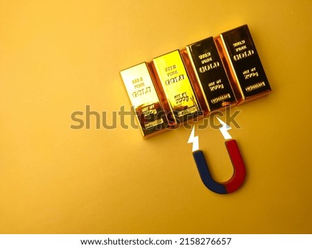 Selective focus.Top view magnet attract the gold bar on a yellow background.
