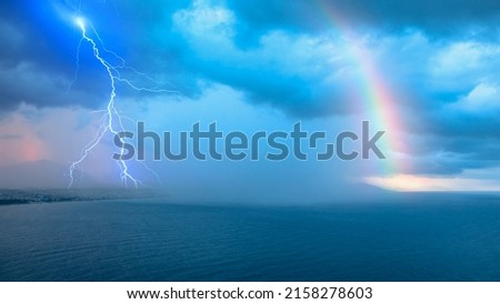 Storm over the sea with lightning and rainbow