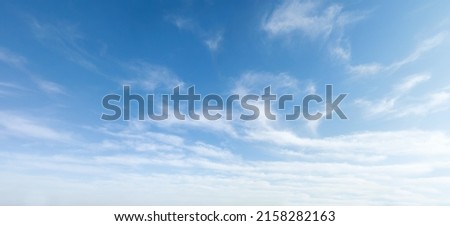 Wide angle photo of sunny and windy weather sky with blue tones. Summer or spring sky with cloudscape. Royalty-Free Stock Photo #2158282163