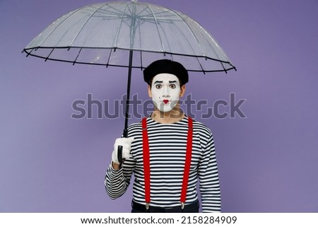 Charismatic amazing marvelous vivid young mime man with white face mask wears striped shirt beret look camera hold transparent umbrella isolated on plain pastel light violet background studio portrait