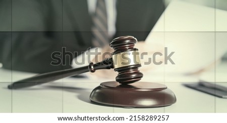 Judge gavel with lawyer working on legal document in background, geometric pattern