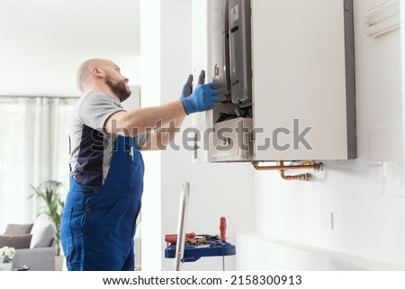 Professional engineer doing a boiler inspection at home Royalty-Free Stock Photo #2158300913