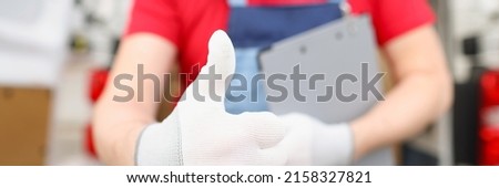 Male courier shows hand in glove gesture ok