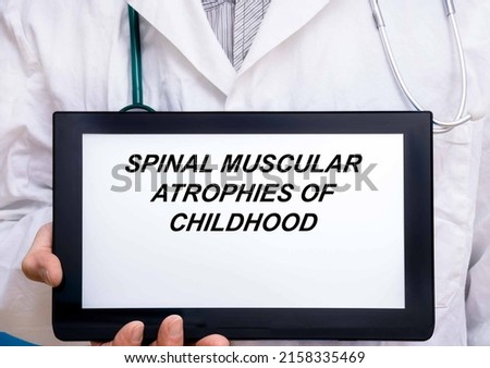 Spinal Muscular Atrophies Of Childhood.  Doctor with rare or orphan disease text on tablet screen Spinal Muscular Atrophies Of Childhood Royalty-Free Stock Photo #2158335469