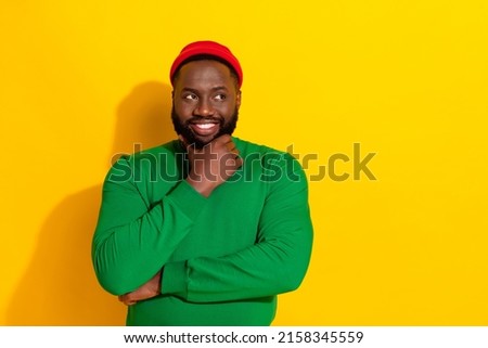 Photo of thoughtful minded guy finger chin look empty space wear red beanie green shirt isolated yellow color background