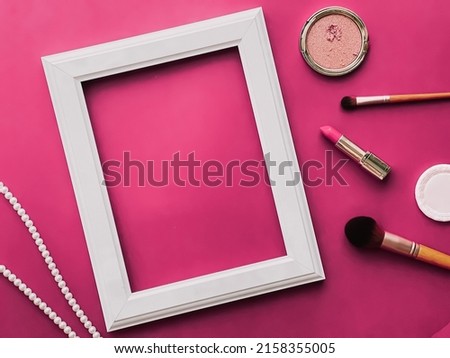 White vertical art frame, make-up products and pearl jewellery on pink background as flatlay design, artwork print or photo album concept