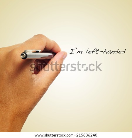 the sentence I am left-handed handwritten by a left-handed person on a beige background Royalty-Free Stock Photo #215836240